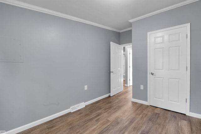 unfurnished bedroom with ornamental molding and dark hardwood / wood-style floors