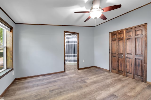 unfurnished bedroom featuring connected bathroom, crown molding, lofted ceiling, ceiling fan, and light hardwood / wood-style flooring