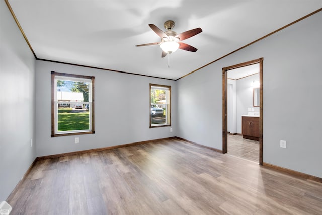 empty room featuring light hardwood / wood-style floors, ceiling fan, and crown molding