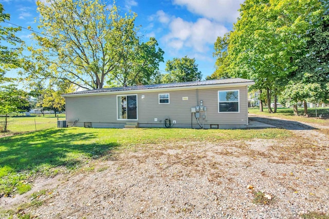 back of house with central AC and a yard