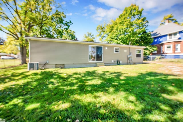 back of property featuring cooling unit and a lawn