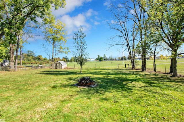 view of yard with a storage shed and a rural view