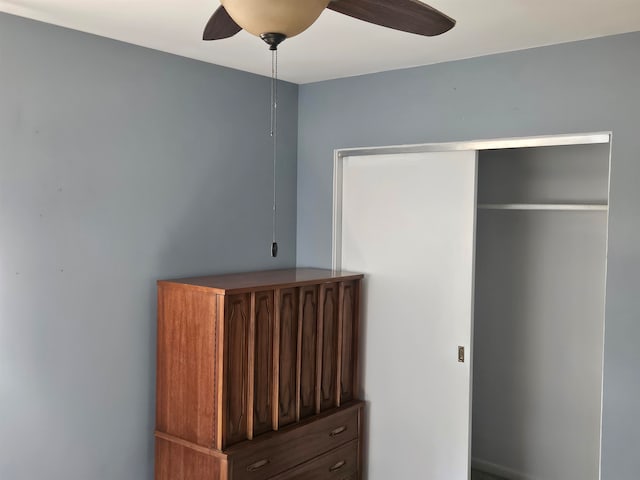 unfurnished bedroom with ceiling fan and a closet