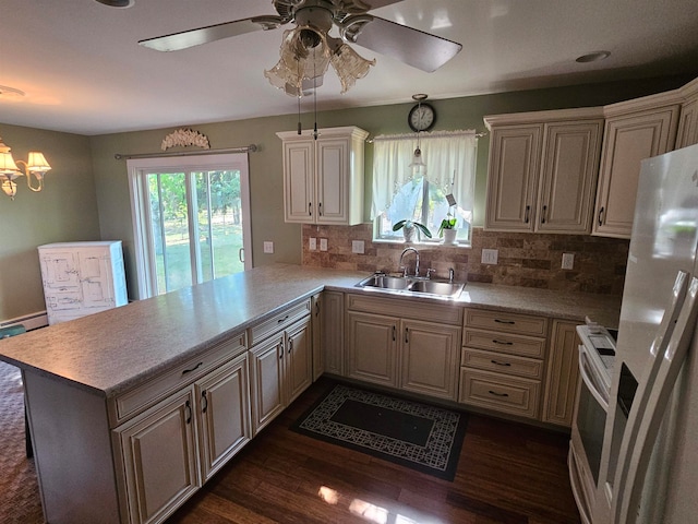 kitchen with dark hardwood / wood-style floors, sink, kitchen peninsula, hanging light fixtures, and stainless steel appliances