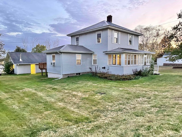 back house at dusk with a lawn