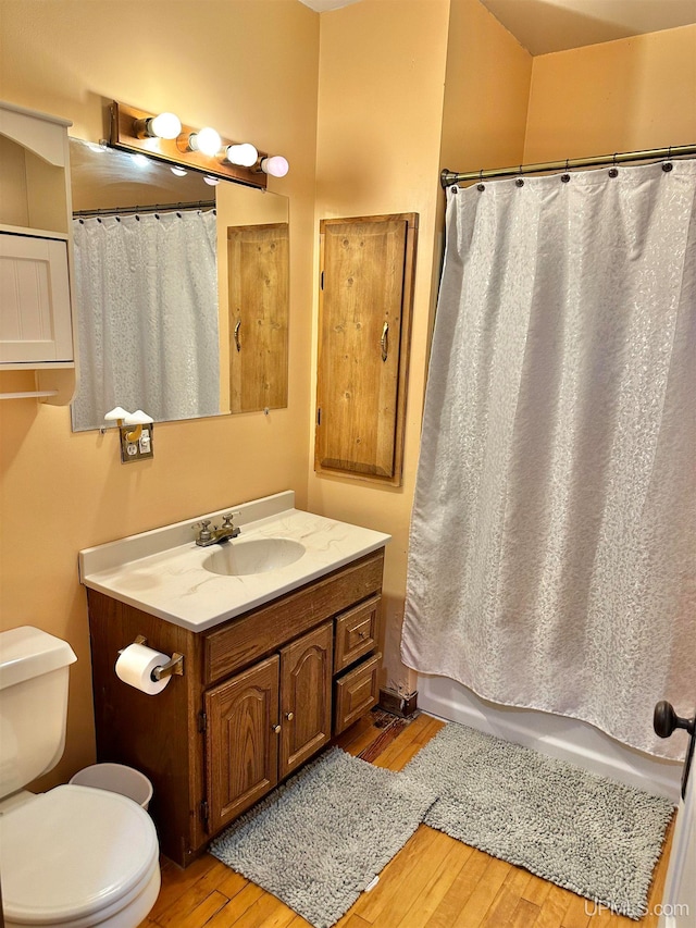 full bathroom featuring vanity, toilet, shower / bath combo with shower curtain, and hardwood / wood-style flooring