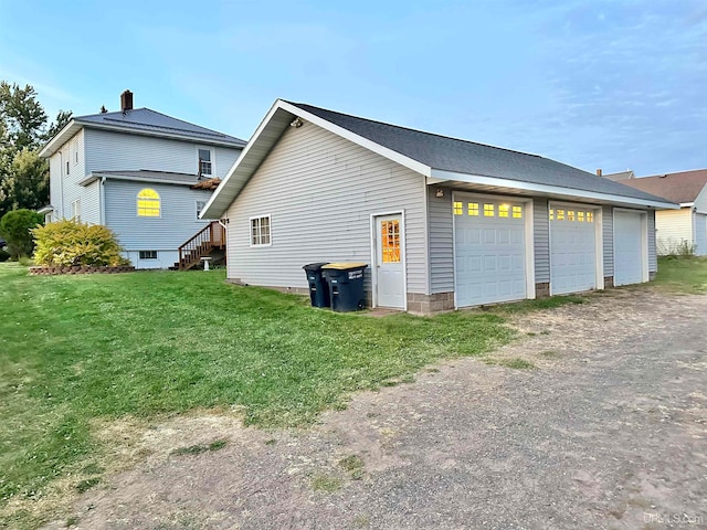 view of side of home featuring a garage and a yard