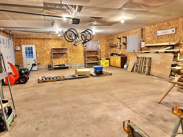 garage with a garage door opener and a workshop area