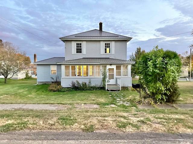 rear view of house featuring a lawn