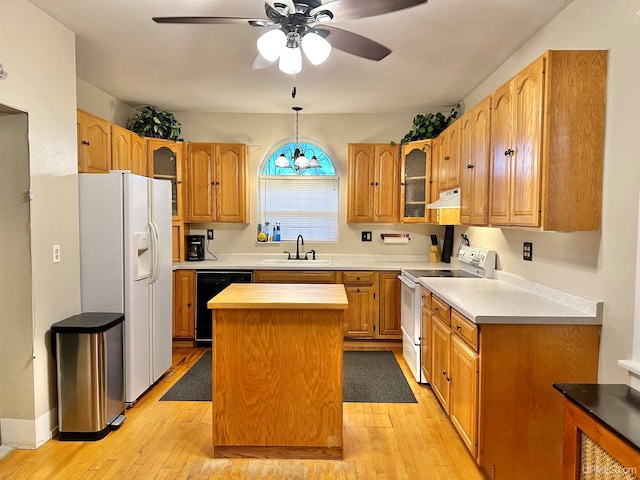 kitchen featuring a center island, sink, hanging light fixtures, light hardwood / wood-style flooring, and white appliances