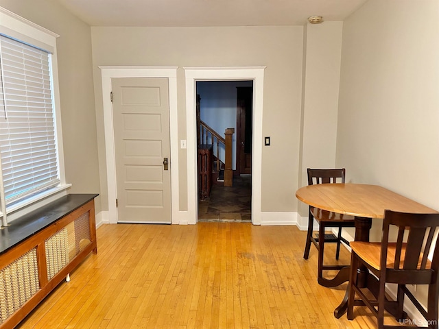 dining space with radiator heating unit and light wood-type flooring