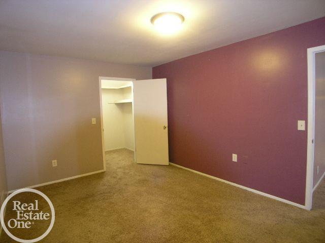 unfurnished bedroom with a closet, a walk in closet, and carpet flooring