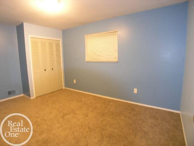 unfurnished bedroom with carpet and a closet