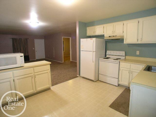 kitchen with white appliances, sink, and white cabinets