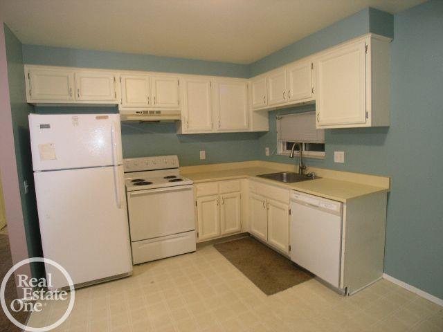 kitchen with white cabinets, white appliances, and sink