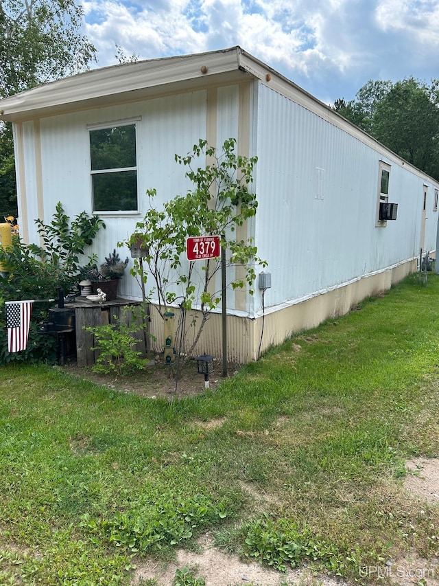 view of side of home featuring cooling unit and a yard