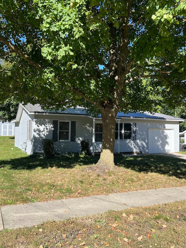 view of front of property featuring a front yard and a garage