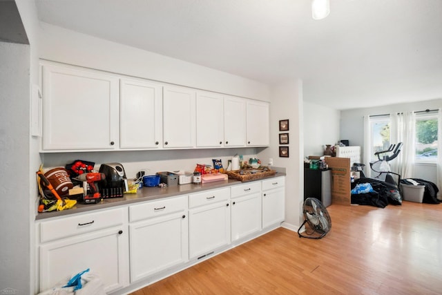 kitchen with light hardwood / wood-style flooring and white cabinets