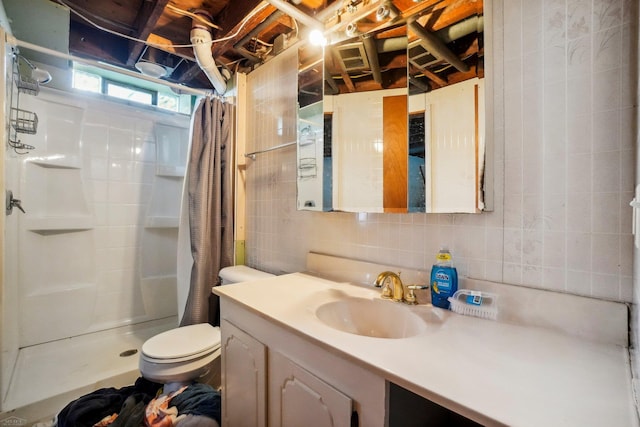 bathroom with tile walls, decorative backsplash, curtained shower, vanity, and toilet