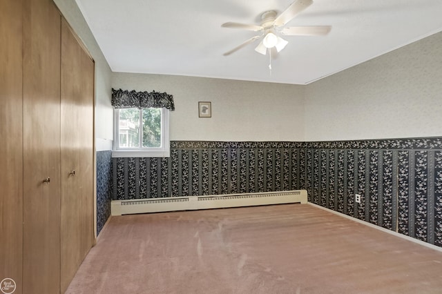 empty room with ceiling fan, a baseboard radiator, and carpet flooring