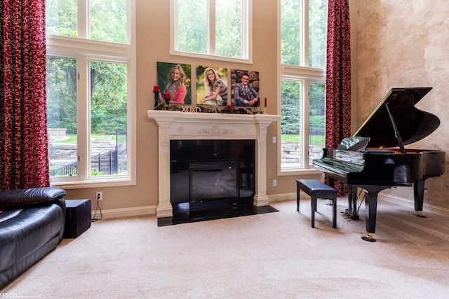 living area with a towering ceiling and carpet flooring