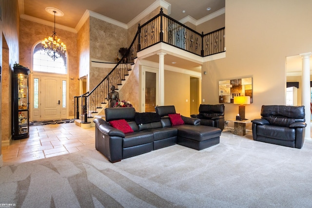 living room with crown molding, a towering ceiling, a chandelier, and ornate columns