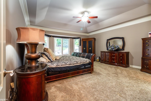 bedroom with ornamental molding, a tray ceiling, ceiling fan, and carpet