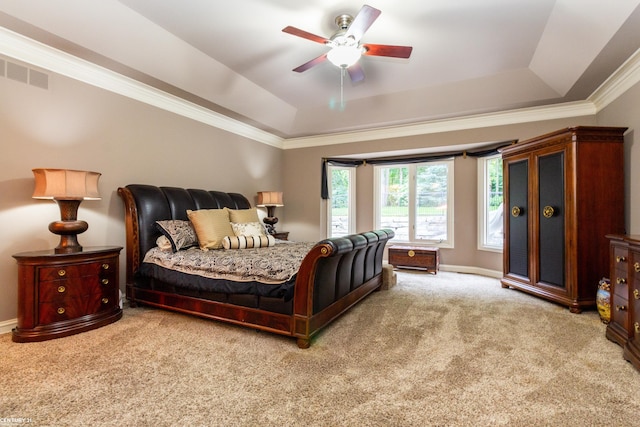 carpeted bedroom with ornamental molding, a tray ceiling, and ceiling fan