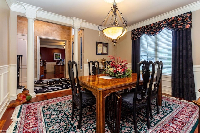 dining room with wood-type flooring, crown molding, and ornate columns