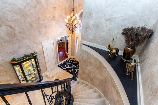 stairway with a high ceiling and a chandelier