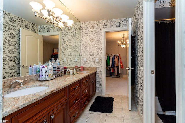 bathroom featuring a notable chandelier, vanity, and tile patterned flooring