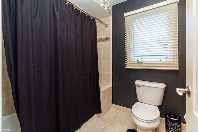 bathroom featuring tile patterned flooring, shower / tub combo, and toilet