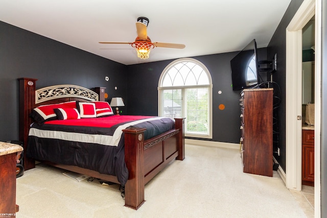 carpeted bedroom featuring ceiling fan and ensuite bathroom