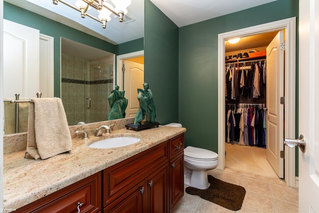 bathroom featuring vanity, a shower with shower door, tile patterned floors, an inviting chandelier, and toilet