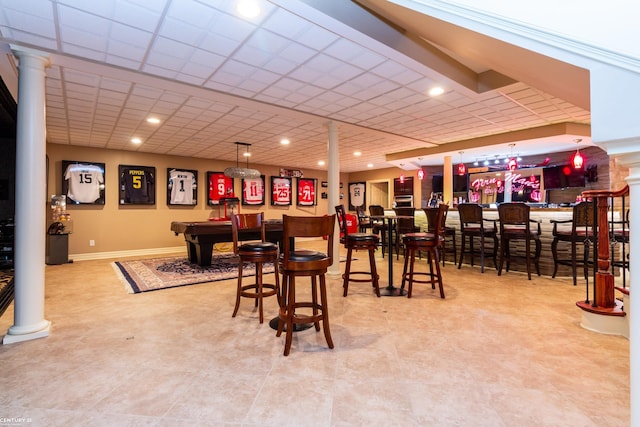 dining space with a paneled ceiling, pool table, and indoor bar