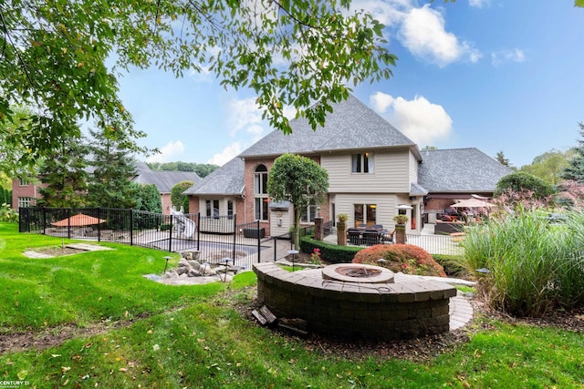 back of property with a lawn, a patio area, and an outdoor fire pit