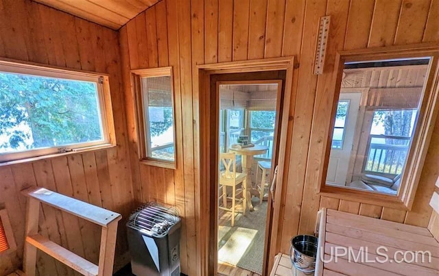 doorway to outside featuring wooden walls and wooden ceiling