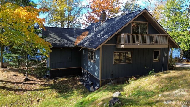 exterior space featuring a balcony and a lawn