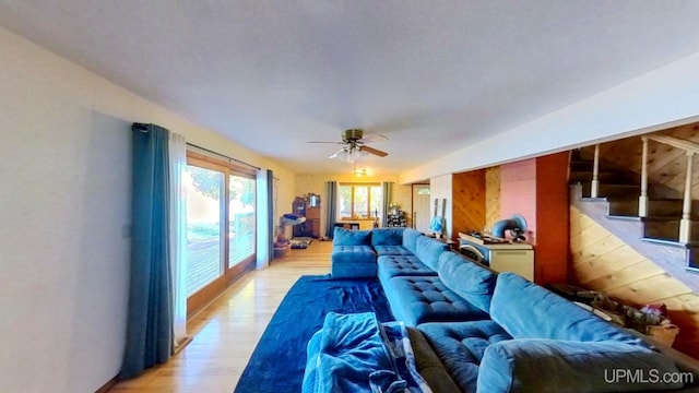 living room with light wood-type flooring, vaulted ceiling, and ceiling fan