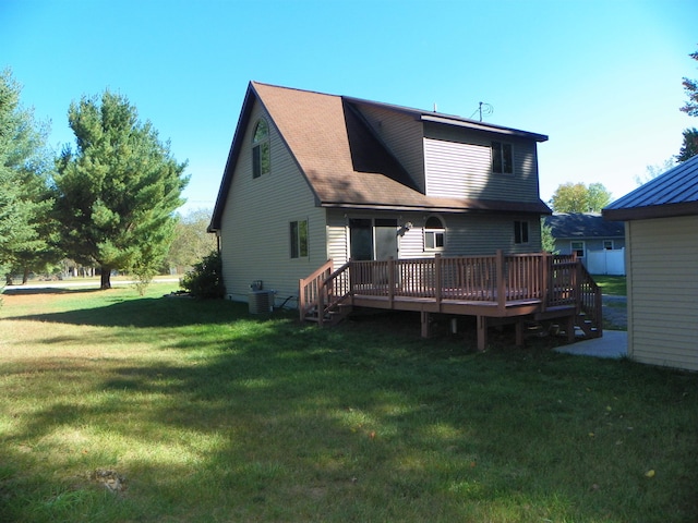 back of property with a wooden deck, a lawn, and central AC