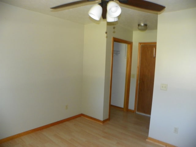 spare room with light wood-type flooring and ceiling fan