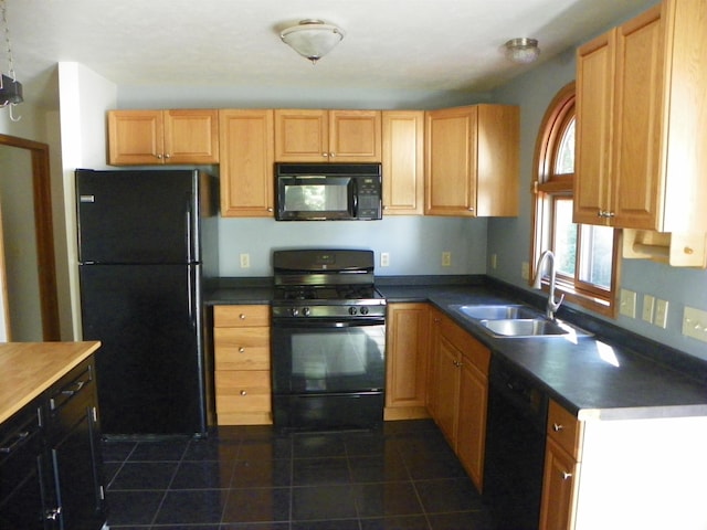 kitchen with dark tile patterned flooring, black appliances, and sink