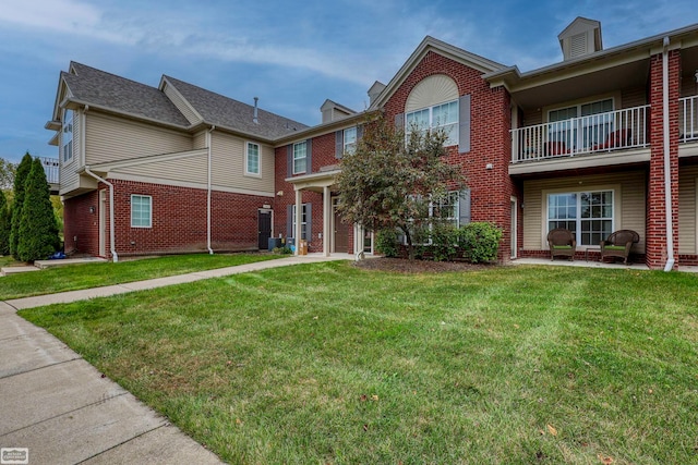 view of front of home with a balcony and a front lawn