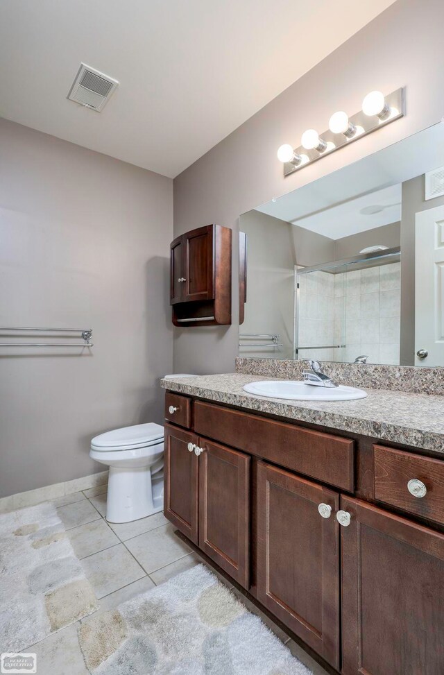 bathroom featuring vanity, toilet, and a shower with shower door