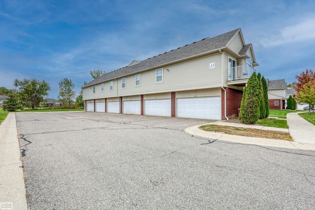 view of side of property with a balcony and a garage