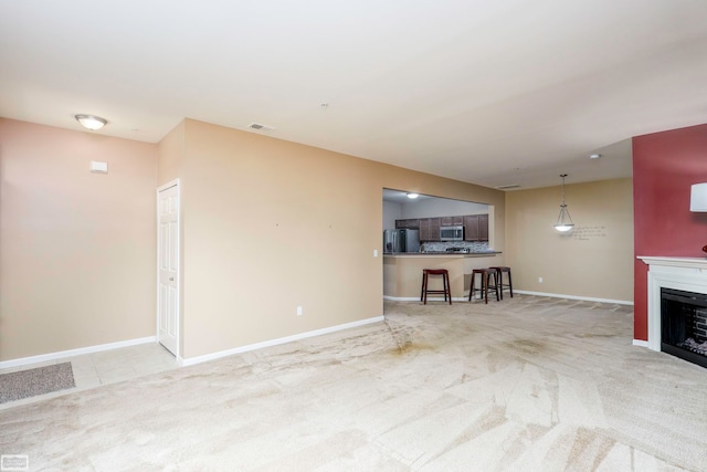 unfurnished living room featuring light colored carpet