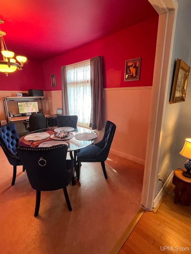 dining room with light hardwood / wood-style flooring and an inviting chandelier