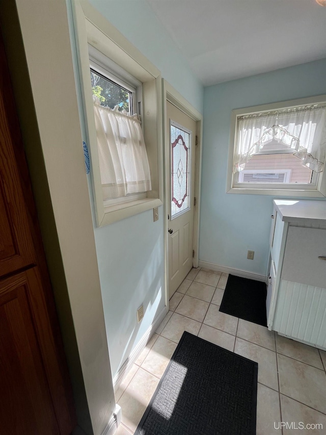 entryway with a wealth of natural light and light tile patterned floors