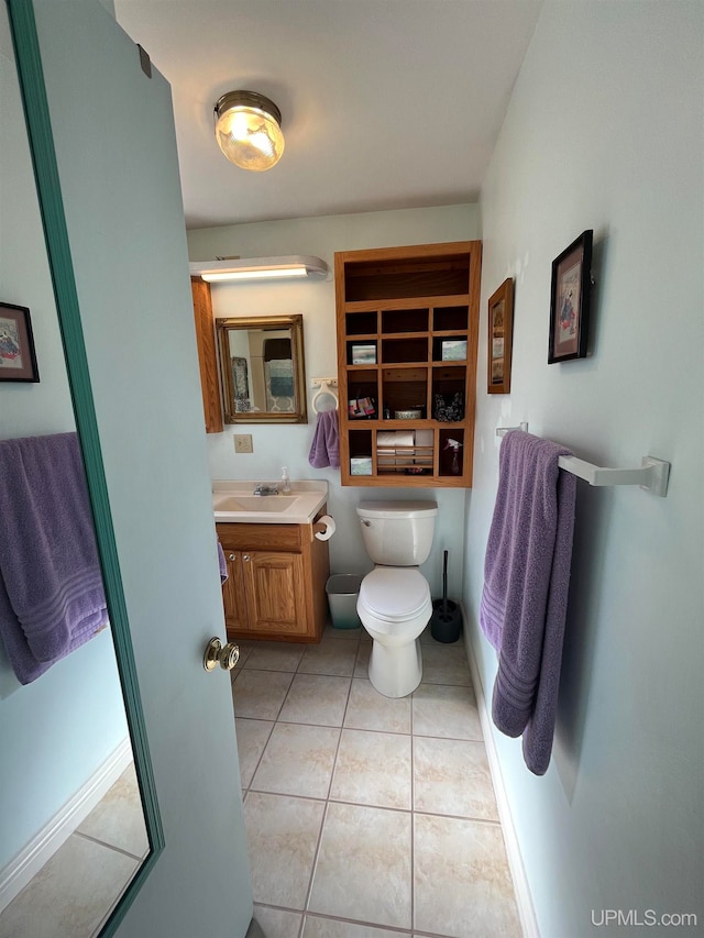 bathroom with toilet, vanity, and tile patterned floors