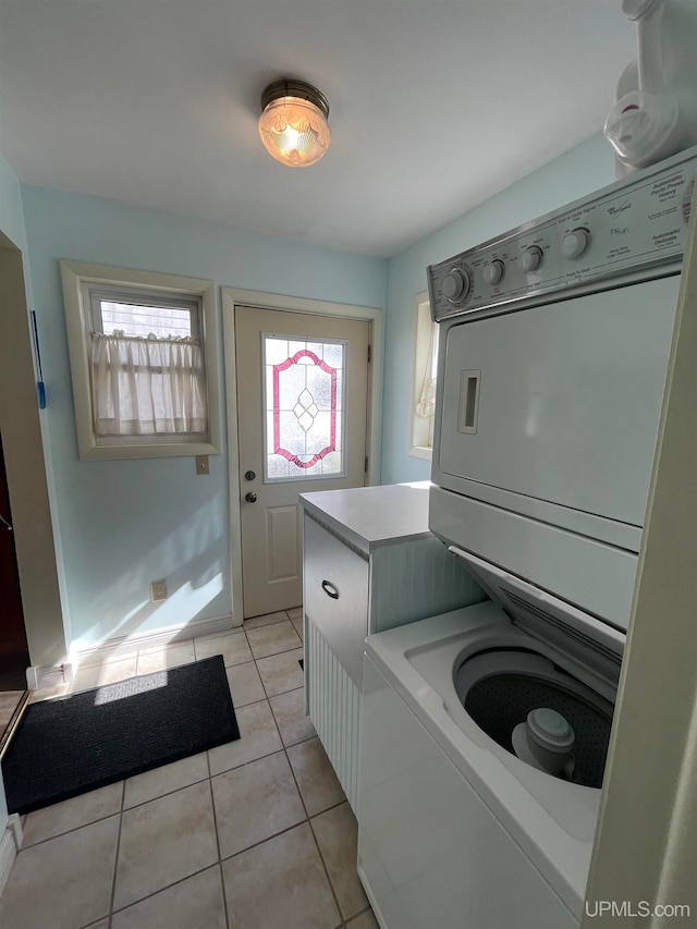 laundry room with stacked washing maching and dryer and light tile patterned floors